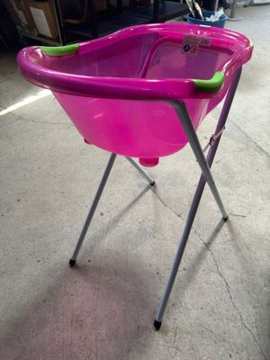 baignoire pour bébé rose avec une poignée et des pieds verts