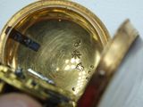 a close up of a person holding a gold pocket watch