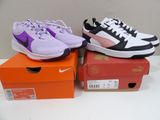 two pairs of shoes are sitting on top of boxes on a table