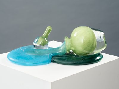 a glass sculpture of a snail with a bottle on top of it