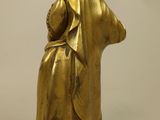 gold statue of a woman holding a baby on a wooden base