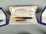 a pen and a ring in a box on a table