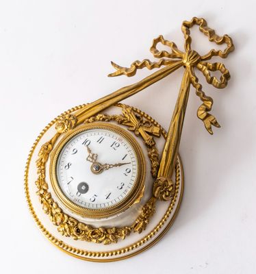a gold clock with a chain hanging from it ' s side