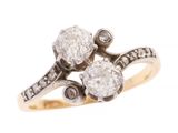 un gros plan d'une bague en diamant et en or sur fond blanc