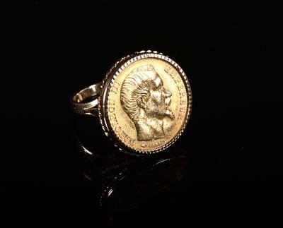 Gros plan sur une bague en or ornée d'une pièce de monnaie