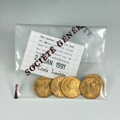 cinq pièces d'or dans un sachet transparent avec un ticket
