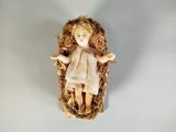 une petite figurine représentant l'Enfant Jésus dans un panier