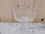 un verre à vin posé sur une table près d'un mur en bois