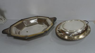 une paire d'assiettes en métal argenté et un bol en métal argenté posés sur une table