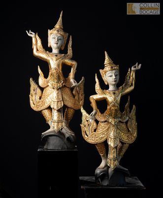 deux statues en or représentant une femme et un homme, posées sur un socle