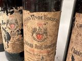 four bottles of wine are lined up on a white surface