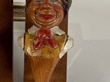 a wooden bottle opener with a wooden face on it