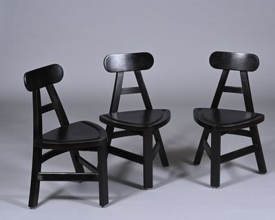 Série de trois chaises en bois massif teinté noir dans l'esp…