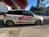 a small white car that is parked on the side of the road