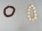 Deux colliers et un bracelet sont posés sur une table