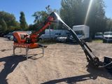 an orange and black machine sitting on top of a dirt field