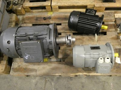 three electric motors sitting on a pallet in a warehouse