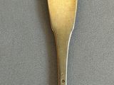 a gold spoon with the letter g on it