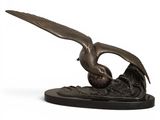 a bronze statue of an eagle on a wave with its wings spread