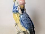 a figurine of a parrot sitting on a branch