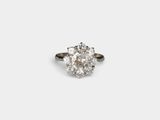 a close up of a diamond ring on a white surface