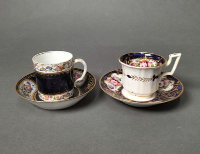 two cups and saucers are sitting side by side on a table