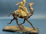statue en bronze représentant une femme à dos de chameau, une lance à la main