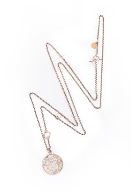 un gros plan d'un collier composé d'une pièce de monnaie suspendue à une chaîne