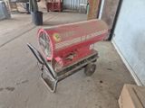 un réfrigérateur rouge posé sur un chariot dans un garage