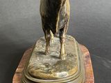 statue of a bull standing on a marble base on a gray background