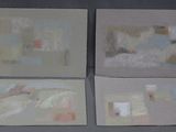 three paintings of different shapes and sizes are displayed on a gray surface