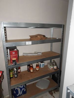 a shelf with bottles and cans on it in the corner of a room