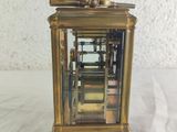 a gold clock that is sitting on a white table