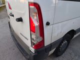 a white van parked in a parking lot next to a house