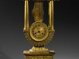 a gold clock that is sitting on a stand