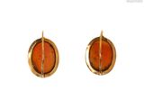an image of a pair of earrings with orange stones on them