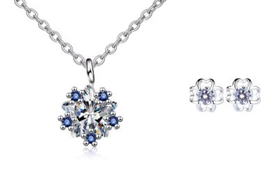 un ensemble composé d'un collier et de boucles d'oreilles ornés de cristaux bleus sur fond blanc