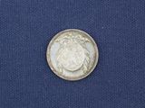 a close up of a silver coin on a blue cloth
