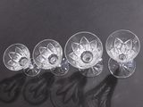 four empty wine glasses sitting on top of a black table