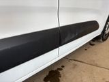 the side of a white car with a black stripe on the side
