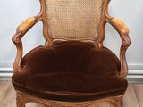 une vieille chaise avec un dossier en rotin et une assise rembourrée marron