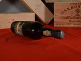 a bottle of wine sitting on a table next to a wooden box