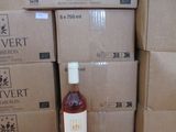 une bouteille de vin posée à côté d'une pile de cartons