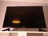 a flat screen tv sitting on top of a white shelf