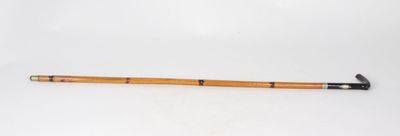 an old wooden stick with a black handle sitting on a white surface