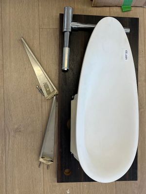 des toilettes blanches posées sur un plancher en bois, à côté d'une paire de ciseaux