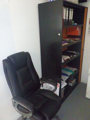 une chaise noire et une bibliothèque noire dans une pièce