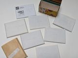 Plusieurs enveloppes sont posées sur une table blanche, à côté d'un sac marron.
