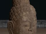 statue of a head of a buddha on a wooden table