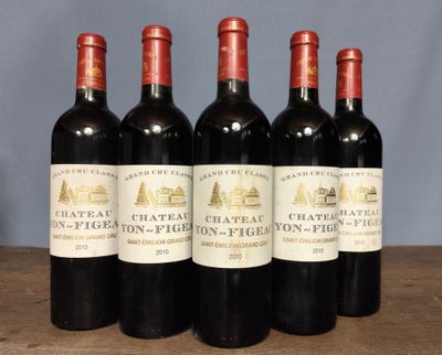 four bottles of wine are lined up on a table